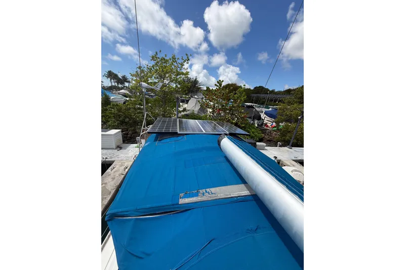 Slide: The Image of 2009 Beneteau Oceanis 40 sailboat with solar panels and blue cover under a sunny sky. - 73