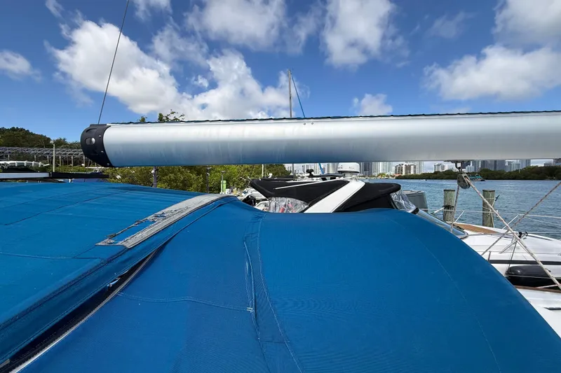 Slide: The Image of 2009 Beneteau Oceanis 40 sailboat with blue cover, docked under a clear sky. - 75