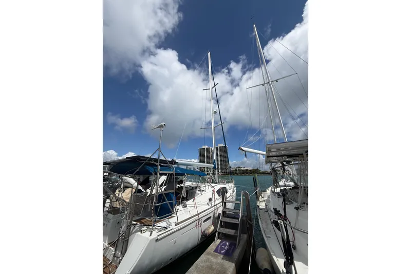 Slide: The Image of 2009 Beneteau Oceanis 40 sailboat docked under a partly cloudy sky. - 90
