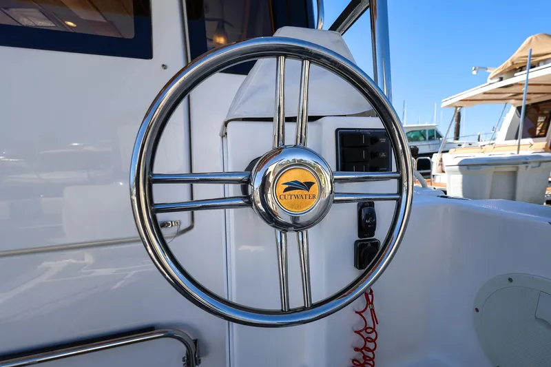 Slide: The Image of Steering wheel of a 2019 Cutwater C-302 Coupe boat, featuring a chrome finish. - 10