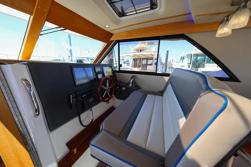 Slide: The Image of Interior of 2019 Cutwater C-302 Coupe boat with modern dashboard and seating. - 12