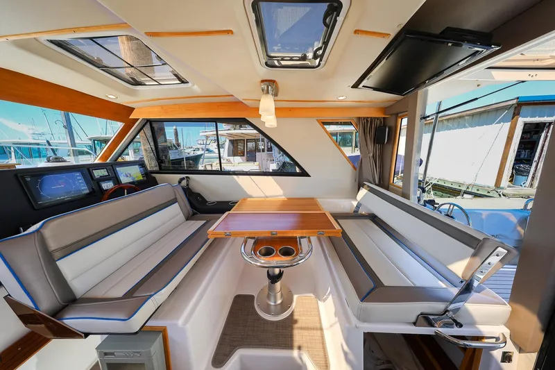 Slide: The Image of Interior of 2019 Cutwater C-302 Coupe boat with seating and table, docked at marina. - 16