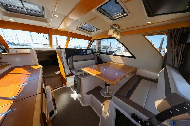 Slide: The Image of Interior of 2019 Cutwater C-302 Coupe boat with modern seating and wooden accents. - 17