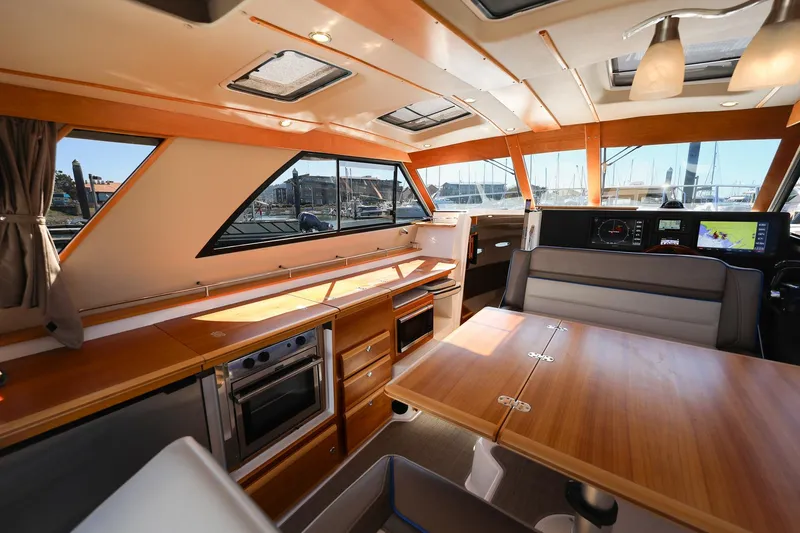 Slide: The Image of 2019 Cutwater C-302 Coupe interior with modern kitchen and dining area. - 18
