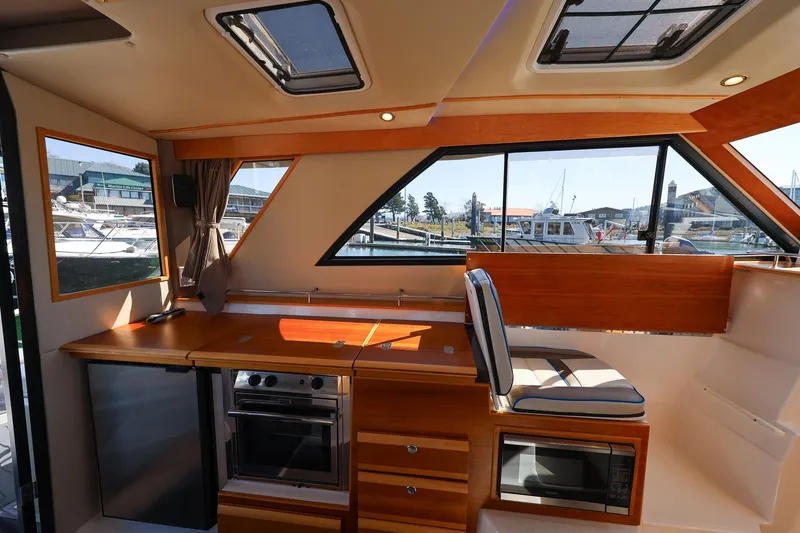 Slide: The Image of Interior of 2019 Cutwater C-302 Coupe boat with kitchen and seating area. - 19