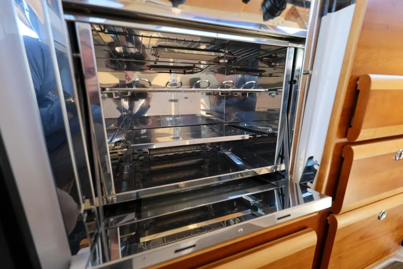 Slide: The Image of Interior of a 2019 Cutwater C-302 Coupe, showcasing a modern stainless steel oven. - 22