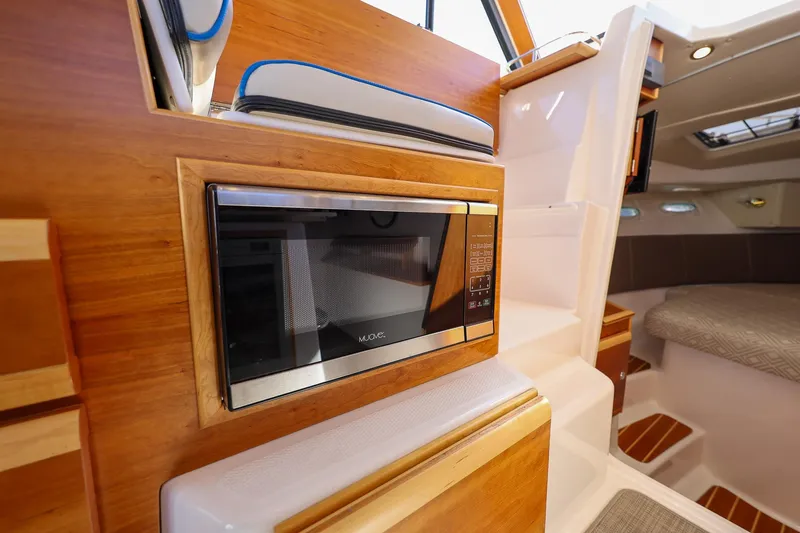 Slide: The Image of 2019 Cutwater C-302 Coupe interior with built-in microwave and cozy cabin seating. - 23