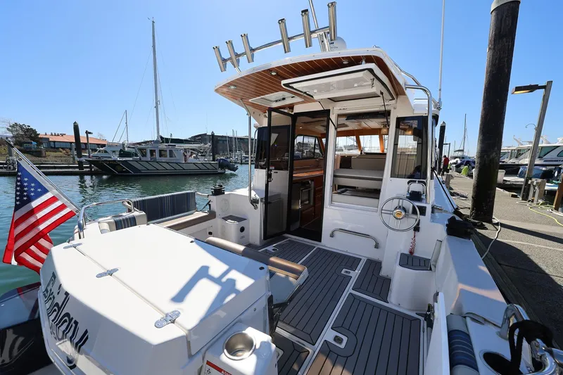 Slide: The Image of 2019 Cutwater C-302 Coupe docked, showcasing spacious deck and American flag. - 3