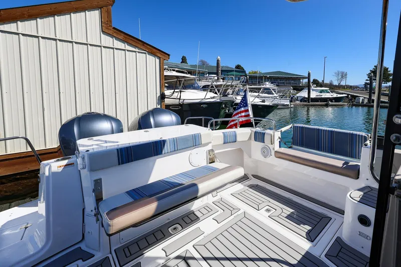 Slide: The Image of 2019 Cutwater C-302 Coupe boat interior with striped seating, docked at marina. - 6