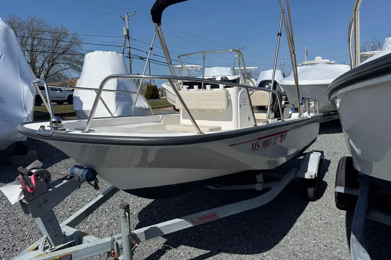 Slide: The Image of 2018 Boston Whaler 150 Montauk boat on trailer, parked outdoors in a marina. - 2