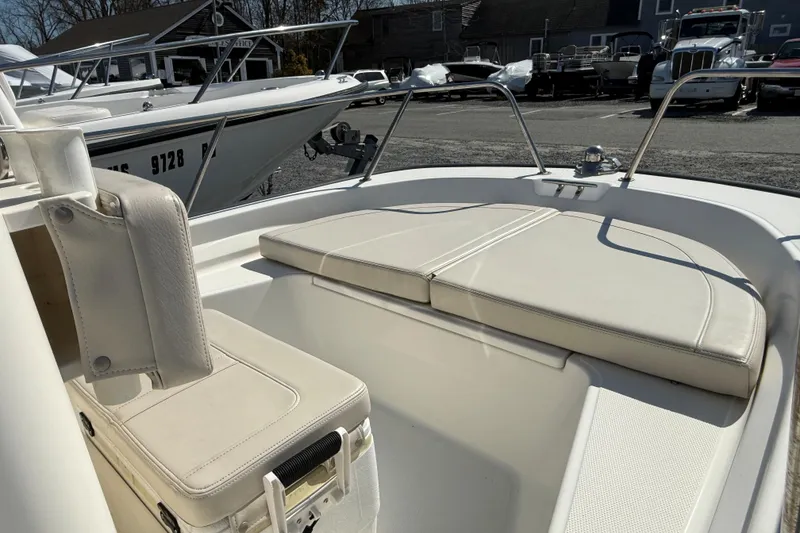 Slide: The Image of 2018 Boston Whaler 150 Montauk boat interior with cushioned seating and storage. - 4