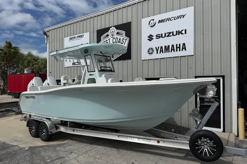 The Image of 2026 Sea Pro 265FLX Sandbar boat on trailer outside dealership with brand logos. - 1
