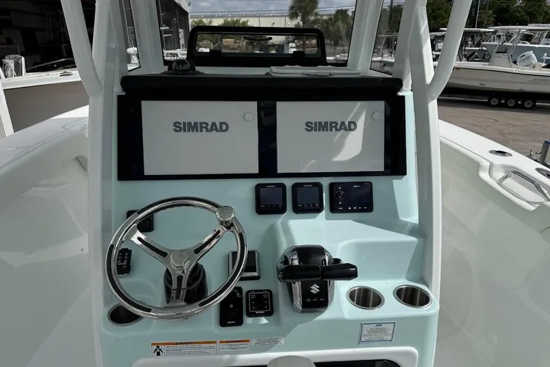 Slide: The Image of 2026 Sea Pro 265FLX Sandbar boat dashboard with dual Simrad displays and steering wheel. - 15