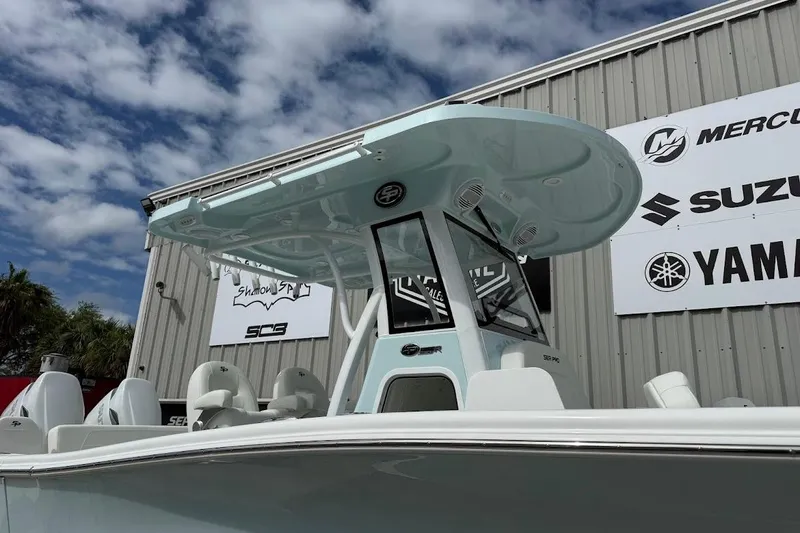 Slide: The Image of 2026 Sea Pro 265FLX Sandbar boat with T-top, displayed outdoors under a cloudy sky. - 2