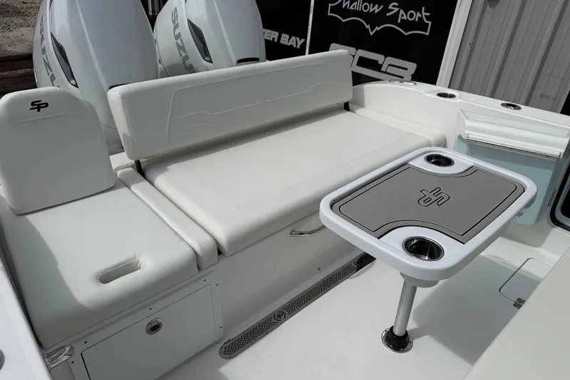 Slide: The Image of 2026 Sea Pro 265FLX Sandbar boat interior with seating and table, featuring dual Suzuki engines. - 20