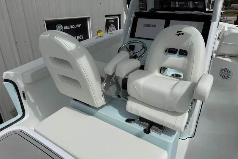 Slide: The Image of 2026 Sea Pro 265FLX Sandbar boat interior with white seating and Simrad navigation system. - 22