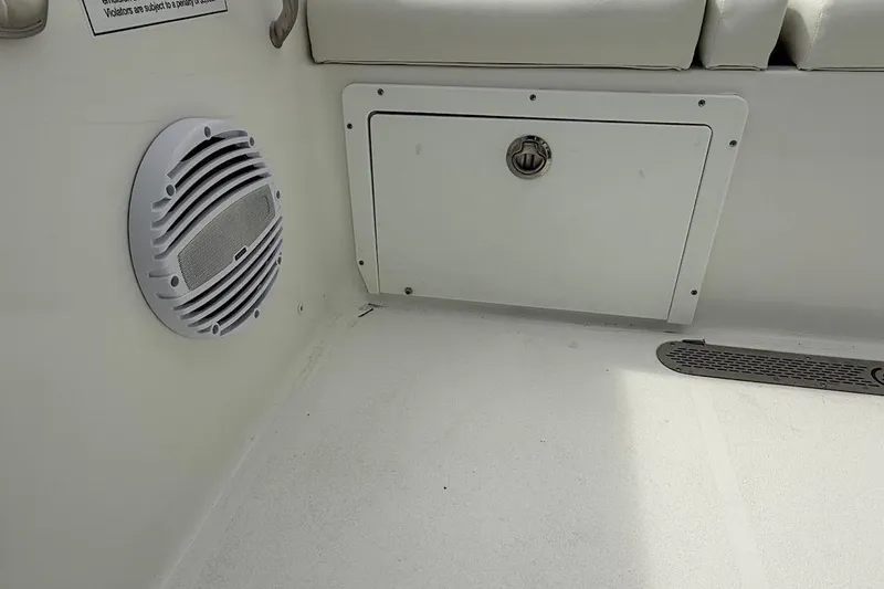 Slide: The Image of Interior of 2026 Sea Pro 265FLX Sandbar boat showing speaker and storage compartment. - 27