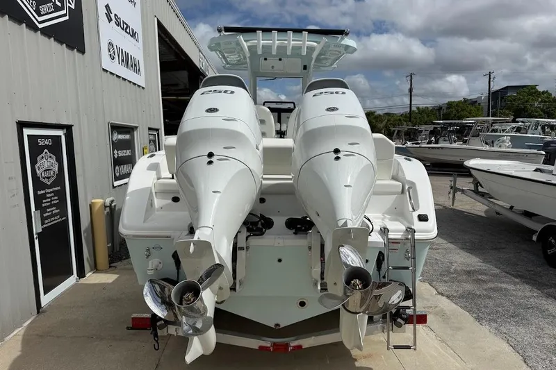 Slide: The Image of 2026 Sea Pro 265FLX Sandbar boat with dual outboard engines at a marine dealership. - 4