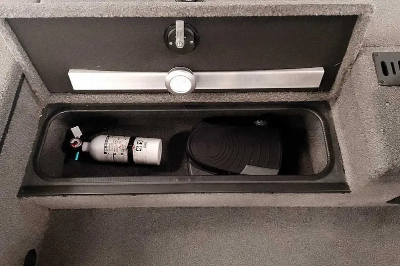 Slide: The Image of Storage compartment in a 2021 Ranger RT178 boat with fire extinguisher and pedal. - 16