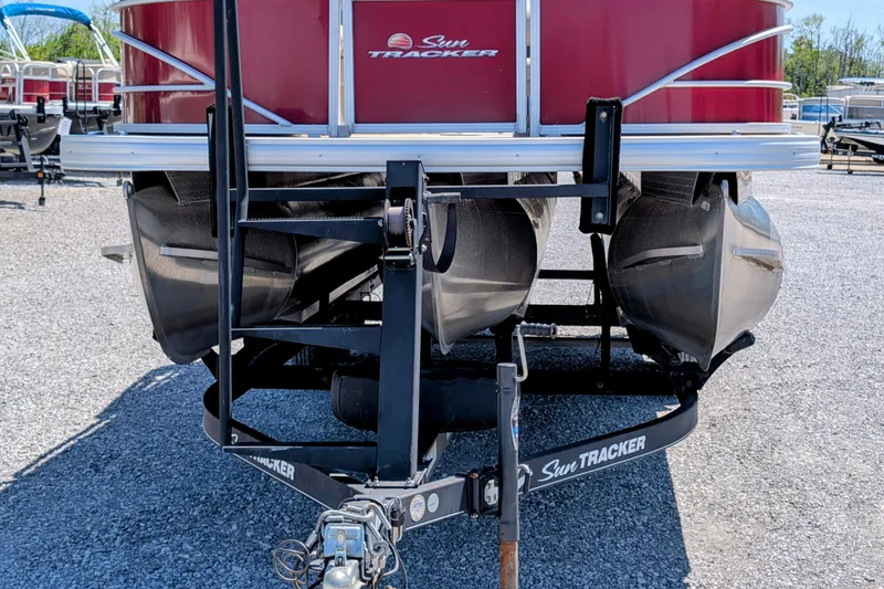 Slide: The Image of 2020 Sun Tracker pontoon boat on trailer, parked on gravel lot. - 3