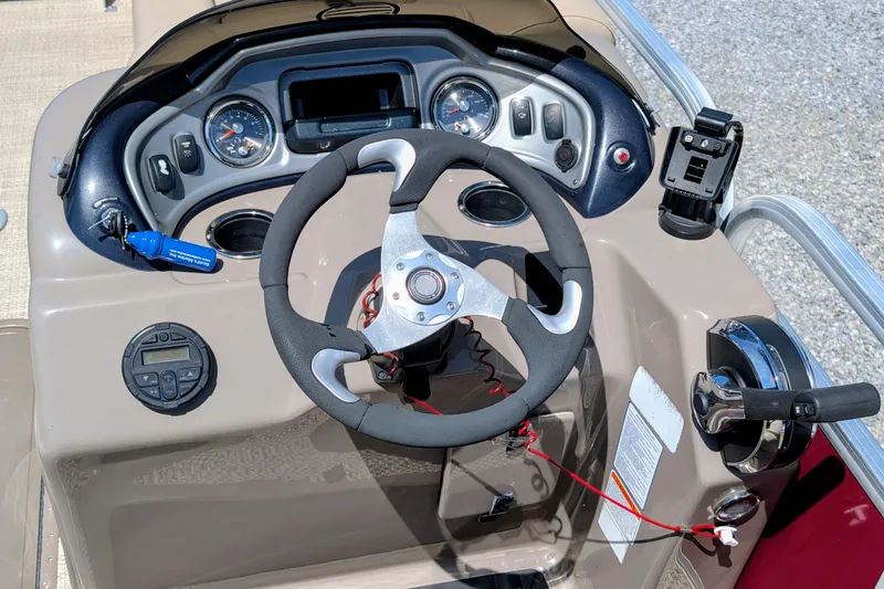 Slide: The Image of 2020 Sun Tracker boat dashboard with steering wheel, gauges, and throttle controls. - 4