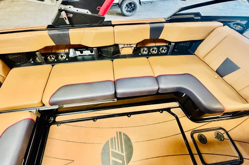 Slide: The Image of 2023 Malibu Wakesetter 23 LSV interior with tan and black seating, cup holders, and logo. - 10