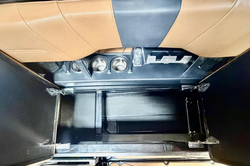 Slide: The Image of 2023 Malibu Wakesetter 23 LSV interior storage compartment with cup holders and tan upholstery. - 12