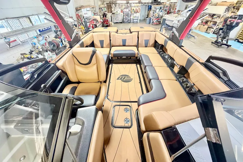 Slide: The Image of 2023 Malibu Wakesetter 23 LSV interior with luxurious tan seating in a workshop setting. - 15