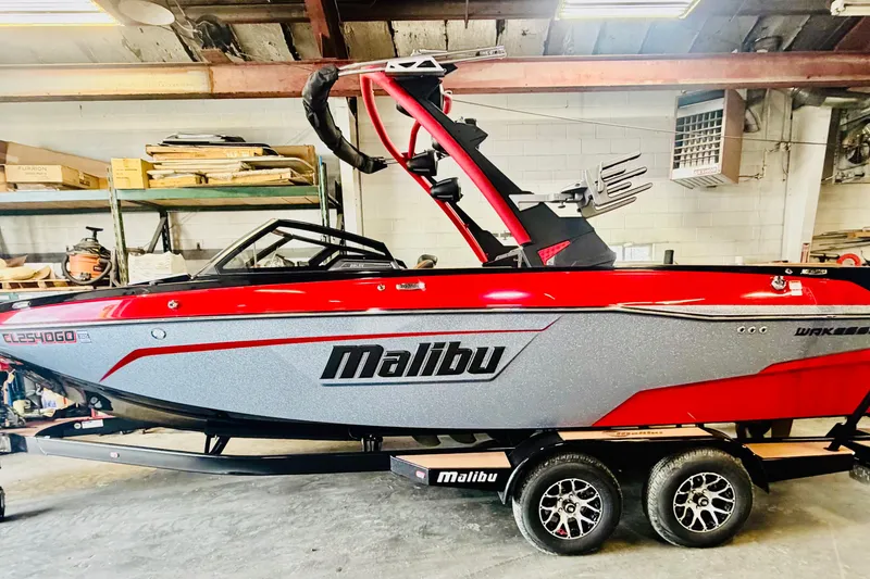 Slide: The Image of 2023 Malibu Wakesetter 23 LSV boat in a garage, red and gray design. - 2