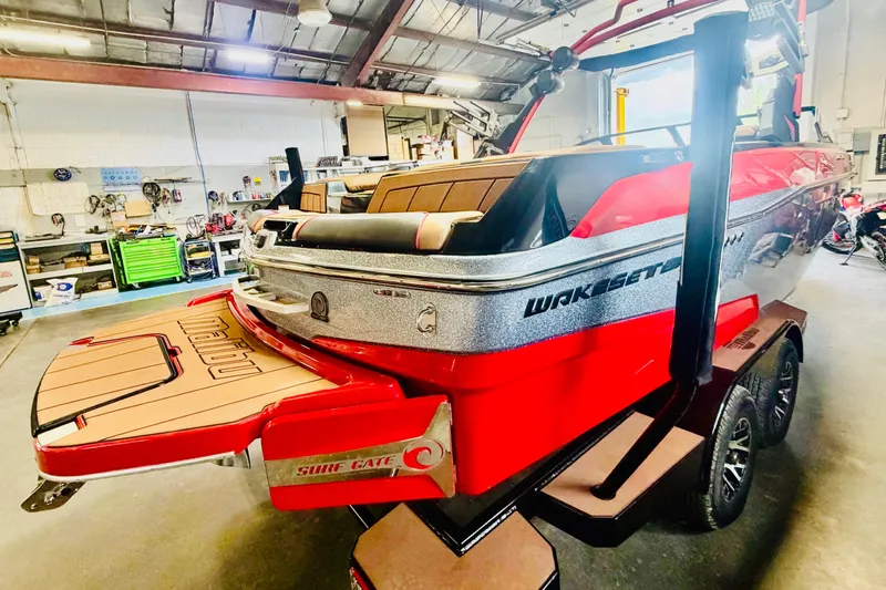Slide: The Image of 2023 Malibu Wakesetter 23 LSV boat in a workshop, showcasing sleek design and vibrant colors. - 4
