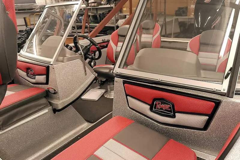 Slide: The Image of 2024 Ranger 1850MS Reata boat interior with red and gray seating and windshield. - 10