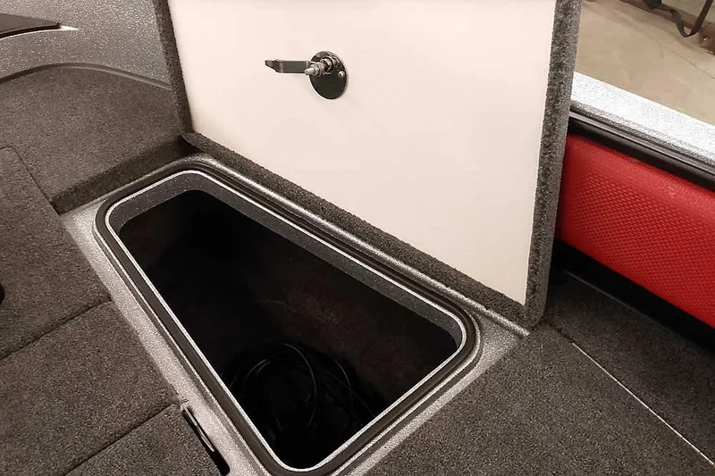 Slide: The Image of 2024 Ranger 1850MS Reata boat storage compartment with open lid and carpeted interior. - 16