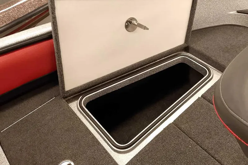 Slide: The Image of 2024 Ranger 1850MS Reata boat storage compartment with open lid and key. - 17