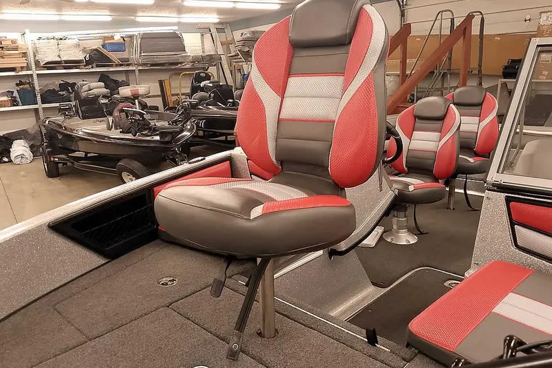 Slide: The Image of 2024 Ranger 1850MS Reata boat interior with red and gray seating in a showroom. - 9