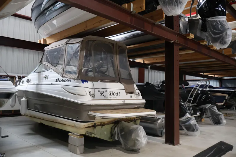 Slide: The Image of 2006 Larson Cabrio 240 boat stored indoors on a rack. - 1