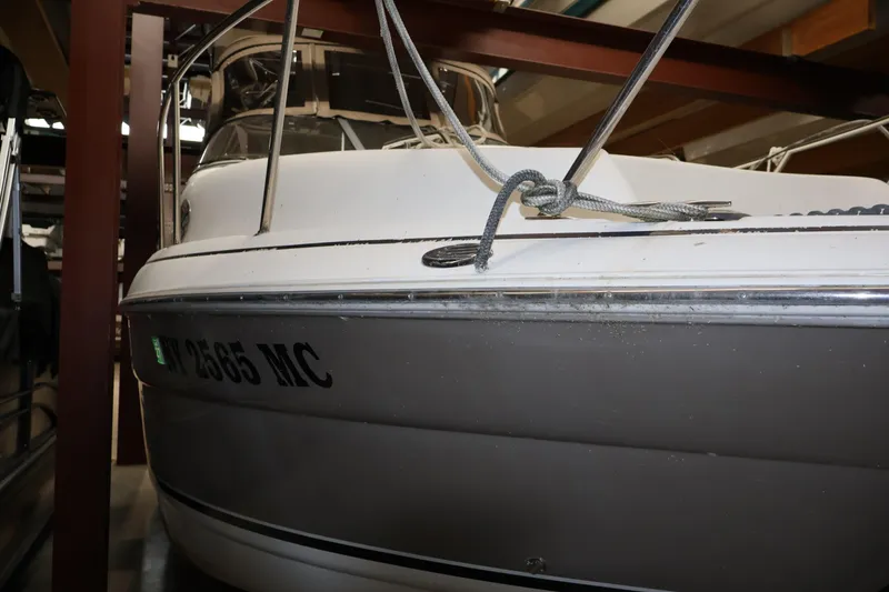 Slide: The Image of 2006 Larson Cabrio 240 boat in storage, featuring a white and gray exterior. - 12