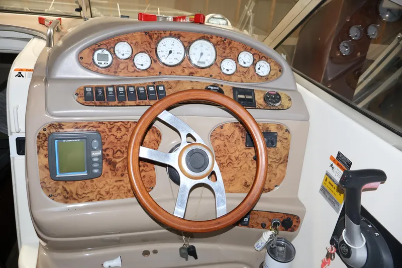 Slide: The Image of 2006 Larson Cabrio 240 dashboard with wood accents and steering wheel. - 14