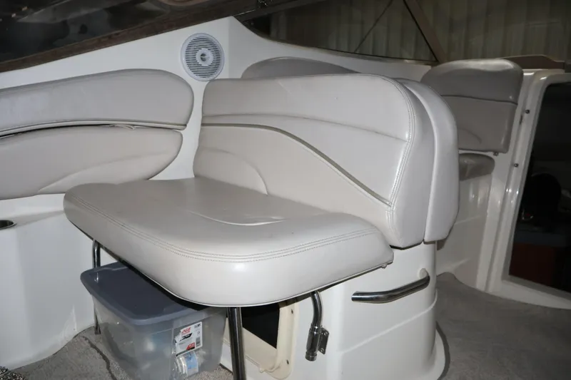 Slide: The Image of 2006 Larson Cabrio 240 boat interior with white leather seating and storage compartment. - 17