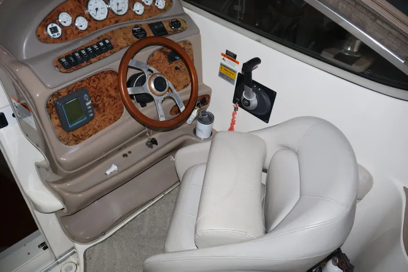 Slide: The Image of Interior cockpit of a 2006 Larson Cabrio 240 boat with steering wheel and control panel. - 19