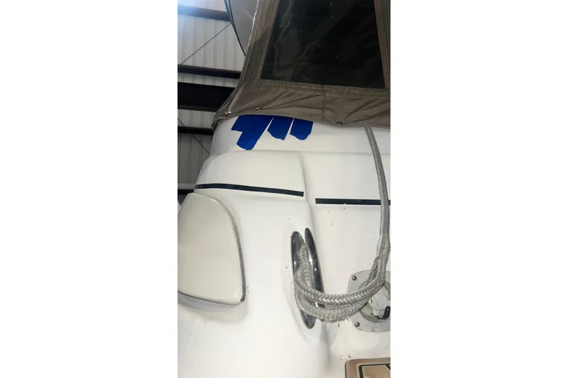 Slide: The Image of 2006 Larson Cabrio 240 boat detail with rope and canopy in storage. - 2