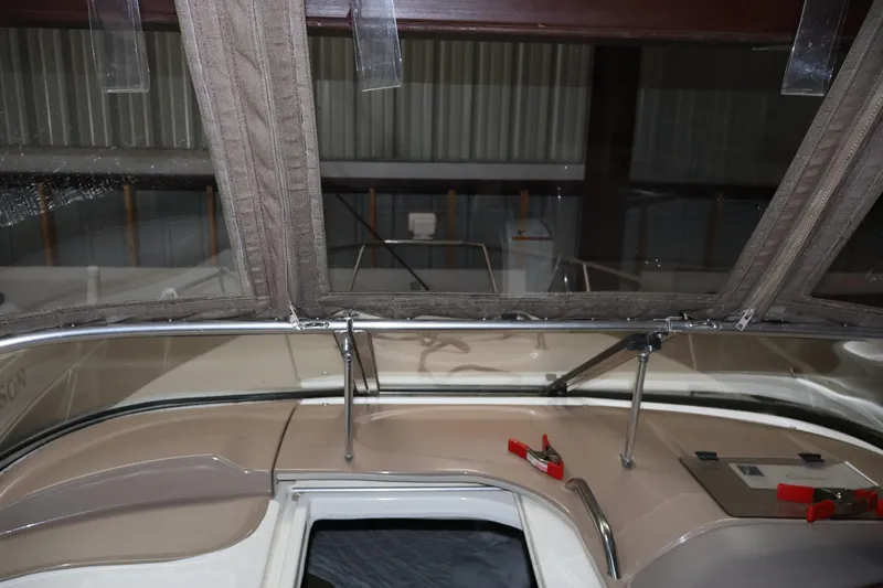 Slide: The Image of 2006 Larson Cabrio 240 boat interior with canopy and control panel in storage. - 23
