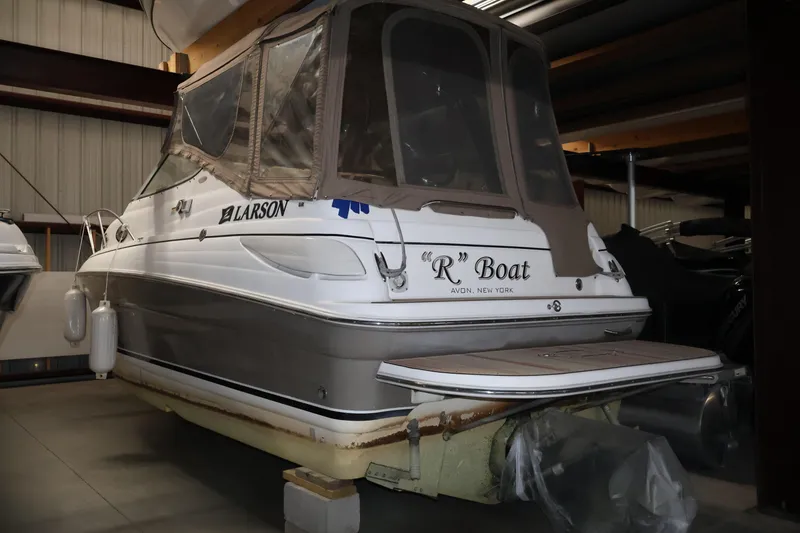 Slide: The Image of 2006 Larson Cabrio 240 boat in storage, featuring covered cockpit and "R" Boat name. - 26
