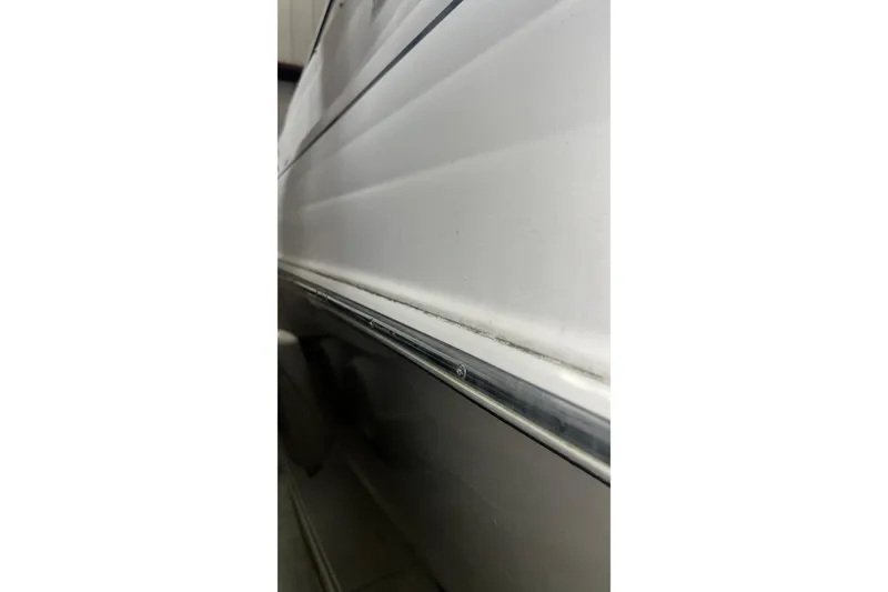 Slide: The Image of Close-up of 2006 Larson Cabrio 240 boat hull, showcasing sleek white exterior design. - 28