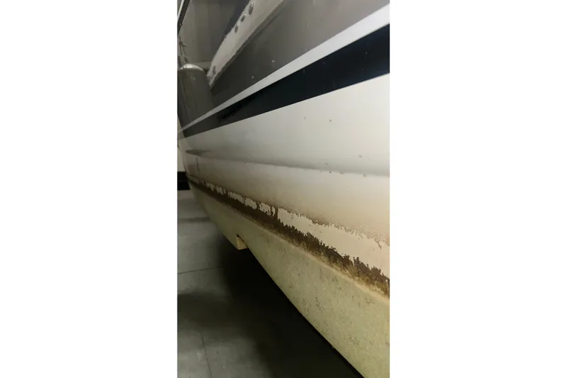 Slide: The Image of 2006 Larson Cabrio 240 boat hull with visible wear and discoloration. - 29