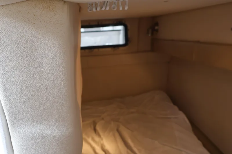 Slide: The Image of Interior cabin of a 2006 Larson Cabrio 240 boat with a small window. - 36