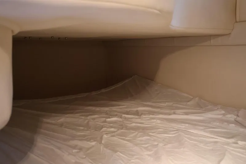 Slide: The Image of Interior cabin space of a 2006 Larson Cabrio 240 boat, featuring beige upholstery. - 37