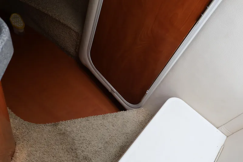 Slide: The Image of Interior of 2006 Larson Cabrio 240 boat with carpeted steps and wooden door. - 38