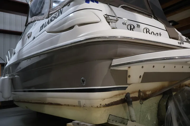 Slide: The Image of 2006 Larson Cabrio 240 boat in storage, showing stern details and nameplate. - 4