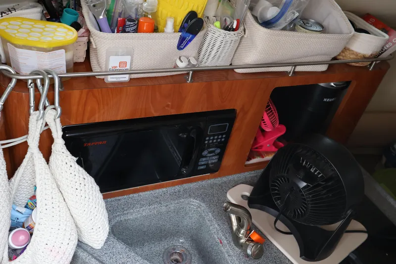 Slide: The Image of Interior of a 2006 Larson Cabrio 240 boat with kitchen essentials and appliances. - 40