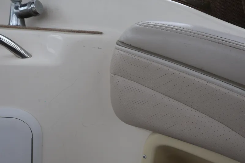 Slide: The Image of Interior detail of a 2006 Larson Cabrio 240 boat, featuring beige upholstery and chrome fixtures. - 41